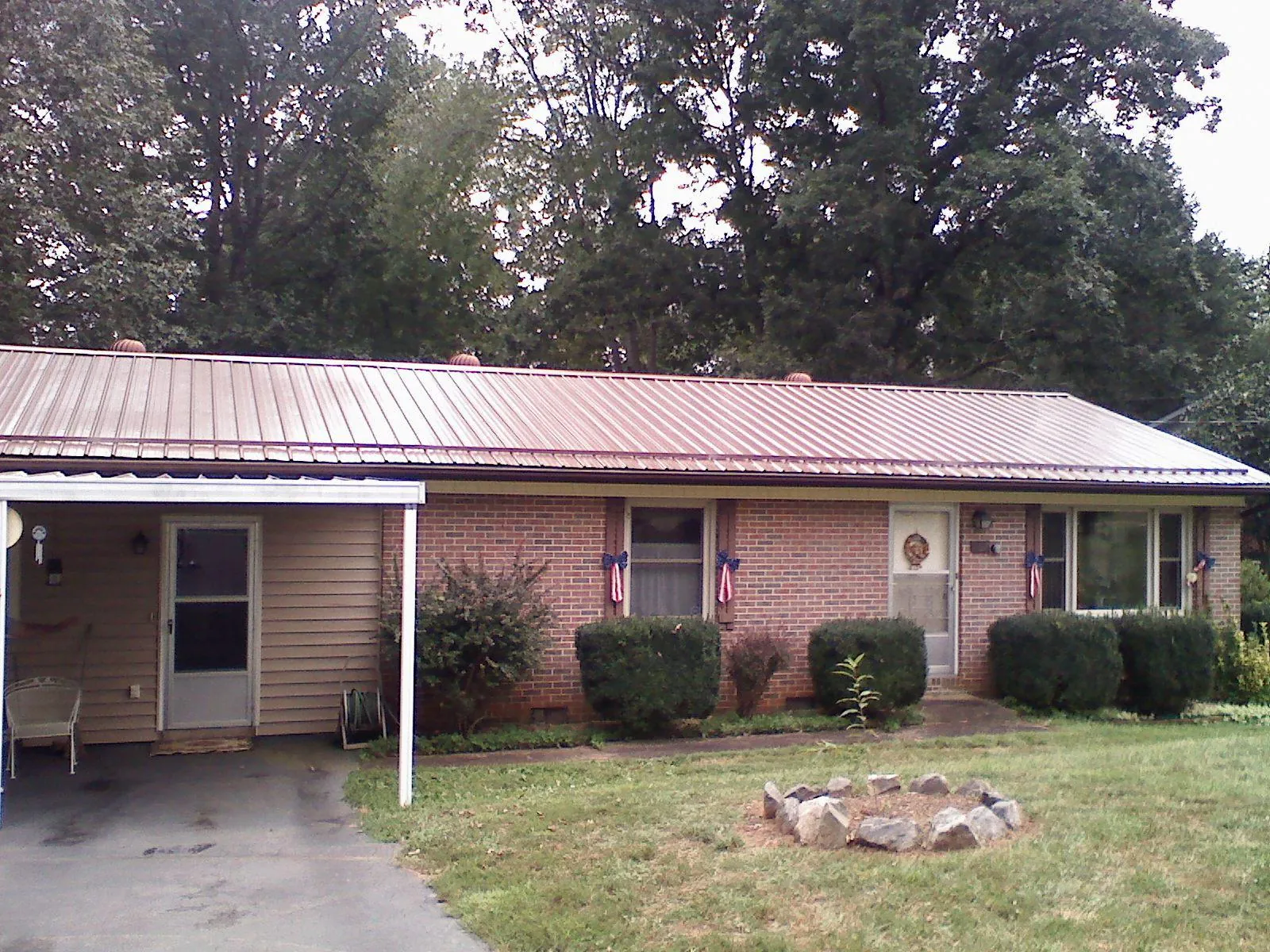 Bronze metal roof and carport on a brick ranch home — Roof Repair work by our crew in Alta Vista